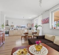 EXKLUZÍVNE 3-izbový rodinný dom v obci Moravské Kračany - Priestranná obývačka s kuchyňou v rodinnom dome, podlaha s dreveným dekorom, svetlé farby.