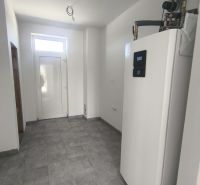 Moderný 4-izbový rodinný dom (dvojdom) v obci Vrakúň - Technická miestnosť v rodinnom dome s tepelným čerpadlom a sivou podlahou.