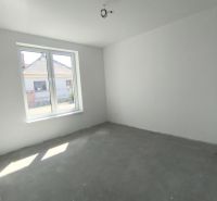 Moderný 4-izbový rodinný dom (dvojdom) v obci Vrakúň - Prázdna izba v rodinnom dome s betónovou podlahou a veľkým oknom.
