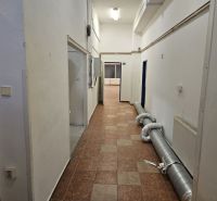Exkluzívny obchodný priestor na predaj v centre Dunajskej Stredy – ul. - Chodba so svetlými stenami, dlažbou a potrubím v obchodných priestoroch.