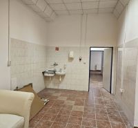 Exkluzívny obchodný priestor na predaj v centre Dunajskej Stredy – ul. - Interiér obchodných priestorov s umývadlami, dlažbou a svetlým kreslom.