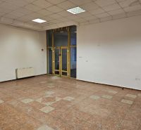 Exkluzívny obchodný priestor na prenájom v centre Dunajskej Stredy – u - Prázdny obchodný priestor s podlahou z dlaždíc, biele steny a veľké okná.