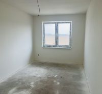 Luxusný dvojdom na predaj v obci Michal na Ostrove - Prázdna miestnosť so sivou podlahou, okno a biele steny v rodinnom dome.