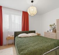 Exkluzívne na predaj – moderný 3-izbový byt so záhradou v Hornej Potôn - Spálňa v 3-izbovom byte s veľkou posteľou, závesmi a podlahou s dreveným dekorom.