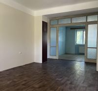 Nová ponuka – 3 izbový byt na predaj v Dunajskej Strede - Prázdna miestnosť v 3-izbovom byte s podlahou s dreveným dekorom a posuvnými dverami.