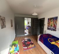 Nová Ponuka! 3 izbový byt na predaj v Dunajskej Strede - Detská izba so zrkadlovou skriňou, plagátmi, hračkami a podlahou s dreveným dekorom.