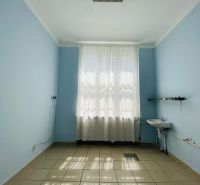 -Na prenájom obchodný priestor 30 m2 v centre mesta Dunajská Streda - Izba s modrými stenami, umývadlom a dlažbou, svetlo preniká cez záclonu.