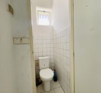 -Na prenájom obchodný priestor 30 m2 v centre mesta Dunajská Streda - Toaleta s dlaždicami na stenách a malým oknom v obchodných priestoroch.