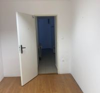 -Na prenájom menší priestor v suteréne  v srdci  mesta Dunajskej Stred - Kancelárie s podlahou s dreveným dekorom a otvorenými dverami.