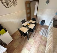 Na predaj kompletne zariadený 3 izbový byt s klimatizáciou aj s balkón - Kuchyňa v 3-izbovom byte s jedálenským stolom a nástennými dekoráciami.