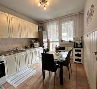 Na predaj kompletne zariadený 3 izbový byt s klimatizáciou aj s balkón - Kuchyňa v 3-izbovom byte s bielymi skrinkami, jedálenským stolom a dlažbou.