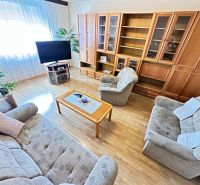Na predaj kompletne zariadený 3 izbový byt s klimatizáciou aj s balkón - Obývačka v 3-izbovom byte ponúka útulný nábytok a podlahu s dreveným dekorom.
