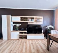 Na predaj priestranný, svetlý  a kompletne zariadený 3-izbový byt s lo - Obývacia izba v 3-izbovom byte s nábytkom a podlahou s dreveným dekorom.