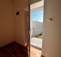 Na predaj 2-izb. byt v dvojdome (110 m²) v štandarde s krbom – Možnosť - Otvorené dvere z rodinného domu vedúce na dvor, s podlahou s dreveným dekorom.