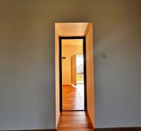 Na predaj 2-izb. byt v dvojdome (110 m²) v štandarde s krbom – Možnosť - Interiér rodinného domu so stenou v svetlej farbe a podlahou s dreveným dekorom.