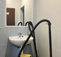 Prenájom obchodný priestor v centre mesta Dunajská Streda - Interiér obchodných priestorov s umývadlom, zrkadlom a vysávačom v miestnosti.