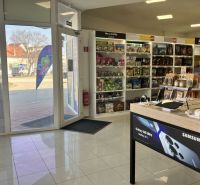 Prenájom obchodný priestor v centre mesta Dunajská Streda - Obchodné priestory s elektronikou a hračkami, podlaha s dreveným dekorom, svetlo z exteriéru.
