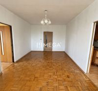 Na predaj 3 izbový byt s balkónom na Sidl.III v Humennom - Obývacia izba v 3-izbovom byte s podlahou s dreveným dekorom a lustrom.