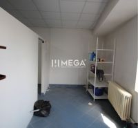 Na prenájom - priestor 185 m2 v centre mesta Humenné - Interiér obchodných priestorov s modrou podlahou, regálom a radiátorom.