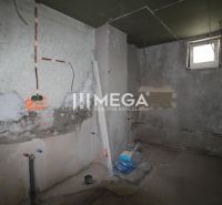 Na predaj - Dom s veľkým pozemkom v Pakostove - Interiér v Rodinnom dome s nedokončenými stenami a stavebným materiálom.