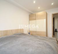 ZNÍŽENÁ CENA EXKLUZÍVNE NA PREDAJ: 3-IZBOVÝ BYT 94 m² | PARKOVACIE MIE - Izba 3-izbového bytu s posteľou, šatníkovou skriňou a podlahou s dreveným dekorom.