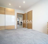 ZNÍŽENÁ CENA EXKLUZÍVNE NA PREDAJ: 3-IZBOVÝ BYT 94 m² | PARKOVACIE MIE - Spálňa v 3-izbovom byte s posuvnou skriňou a dreveným dekorom.