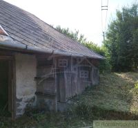Veľký, vyše 4,5Ha slnečný pozemok s chalupou v strede, na lazoch, pri  - Staršia chata v Hrušove s drevenými stenami a šindľovou strechou, obklopená bujnou vegetáciou.