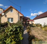 Útulný zrekonštruovaný dom / chalupa pod Slanskými vrchmi- Cabov - Rodinný dom v Cabove s upravenou záhradou a červenou strechou pod modrou oblohou.