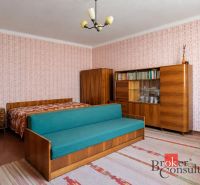Rodinný dom s veľkým pozemkom 2 908 m² v obci Žiar - Izba v rodinnom dome s retro nábytkom, vzorovanými tapetami a sedačkou.