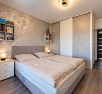 4-izbový dom 96m2 + pozemok 417m2  | Kostolište - Spálňa v rodinnom dome s podlahou s dreveným dekorom, svetlými stenami a posteľou.