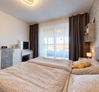 4-izbový dom 96m2 + pozemok 417m2  | Kostolište - Spálňa v rodinnom dome s pohodlnou posteľou, komodou a dekoratívnymi závesmi.