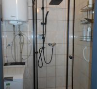 Na predaj 2-izbový rekonštruovaný tehlový byt, 28. októbra  - Kúpeľňa v 2-izbovom byte s preskleným sprchovacím kútom a práčkou.