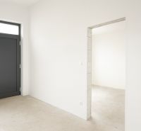 4-izbový rodinný dom Galanta – HODY - bez rezervačnej zálohy - Pohľad do interiéru rodinného domu s bielymi stenami a tmavými dverami.