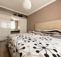 INVESTIČNÁ PRÍLEŽITOSŤ V SRDCI ŠTÚROVA - ZABEHNUTÉ APARTMÁNY - Spálňa v rodinnom dome s posteľou a šatníkovou skriňou, podlaha s dreveným dekorom.