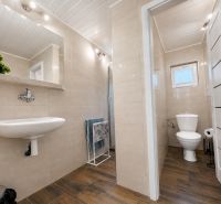 INVESTIČNÁ PRÍLEŽITOSŤ V SRDCI ŠTÚROVA - ZABEHNUTÉ APARTMÁNY - Kúpeľňa v rodinnom dome s podlahou s dreveným dekorom a svetlými obkladačkami.