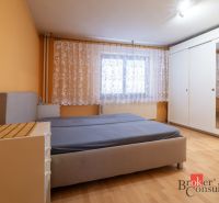 Priestranný rodinný dom v Kysuckom Novom Meste - Spálňa v rodinnom dome s posteľou, skriňou a podlahou s dreveným dekorom.