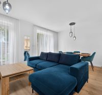 4i RD s pozemkom 170 m2  | ul. Vážska | Trenčín - Obývacia izba v rodinnom dome s modrou sedačkou a podlahou s dreveným dekorom.