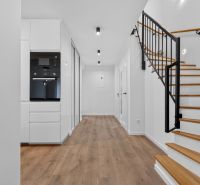 4i RD s pozemkom 170 m2  | ul. Vážska | Trenčín - Interiér rodinného domu s podlahou s dreveným dekorom, bielym nábytkom a schodiskom.