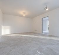 Posledný Voľný - Moderný 4-izbový rodinný dom s terasou a záhradou - Priestranná miestnosť v rodinnom dome s betónovou podlahou a bielymi stenami.