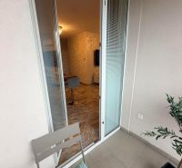Na prenájom moderný 3-izbový byt s terasou, Dun.Streda - Otvorená balkónová dverí do 3-izbového bytu s pohodlným kreslom a podlahou.