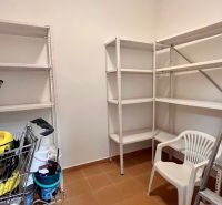 Prenájom kancelárskych priestorov Ružinov, 100 m2,  parking - Úložný priestor s regálmi, biela plastová stolička a kovový rebrík.