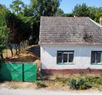 Rodinný dom v centre obce s potokom priamo za domom - Rodinný dom na Námestí sv. Floriána v Krakovanoch, obklopený zeleňou a plotom.