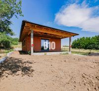 Moderný bungalov v pokojnej časti Čeľadíc – Ideálny domov na skok od N - Rodinný dom v Čeľadiciach s nedokončenou záhradou, obklopený zeleňou a modrou oblohou.
