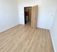 PRENÁJOM KANCELÁRIE 13,5 m² – KOMÁRNO, ZÁHRADNÍCKA ULICA - Kancelária s bielymi stenami a podlahou s dreveným dekorom.