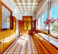 5 IZB. RODINNÝ DOM S ROZĽAHLÝM POZEMKOM 2 751 m² – NADLICE - Chodba v rodinnom dome s kvetmi na parapete a vzorovanou podlahou.