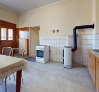 5 IZB. RODINNÝ DOM S ROZĽAHLÝM POZEMKOM 2 751 m² – NADLICE - Kuchyňa v rodinnom dome s jedálenským stolom, sporákom a drevenými skrinkami.