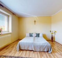 5 IZB. RODINNÝ DOM S ROZĽAHLÝM POZEMKOM 2 751 m² – NADLICE - Spálňa v rodinnom dome s jednoduchou posteľou, dreveným dekorom a kvetmi na okne.