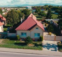 5 IZB. RODINNÝ DOM S ROZĽAHLÝM POZEMKOM 2 751 m² – NADLICE - Rodinný dom v Nadliciach so záhradou a červenou strechou na vidieku.