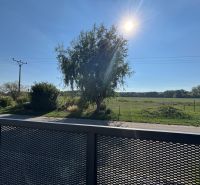 ** NOVOSTAVBA S KRBOM ** 4 izb. RD, ÚP 130m2, pozemok 584m2 – FIGOVÁ - Slnečný deň na Figovej ulici v Bernolákove s výhľadom z rodinného domu na prírodu.