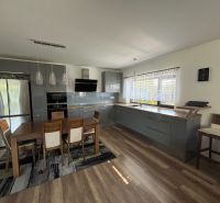 ** NOVOSTAVBA S KRBOM ** 4 izb. RD, ÚP 130m2, pozemok 584m2 – FIGOVÁ - Kuchyňa v rodinnom dome s podlahou s dreveným dekorom a jedálenským stolom.